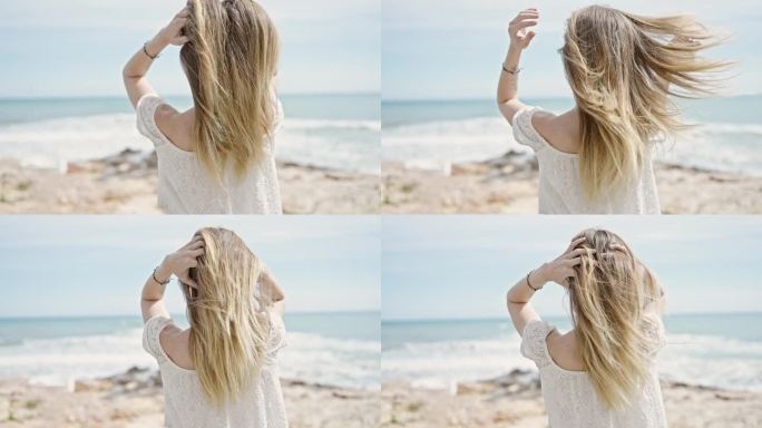 年轻的金发女游客向后站在海滩上抚摸头发