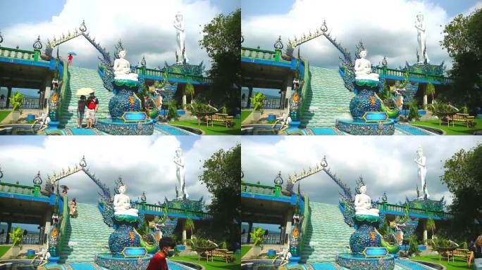 泰国春武里2023年9月9日游客手持彩虹伞在Wat kho pra kru寺白色佛像站和阴云在雨天