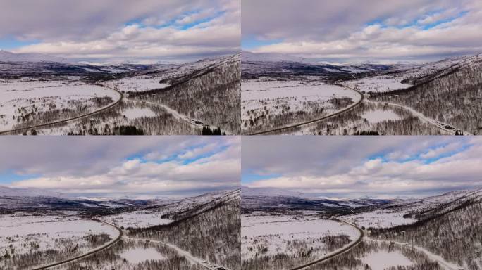 挪威冬季自驾游，航拍森林中风景优美的公路，景观被雪覆盖，白云满天。