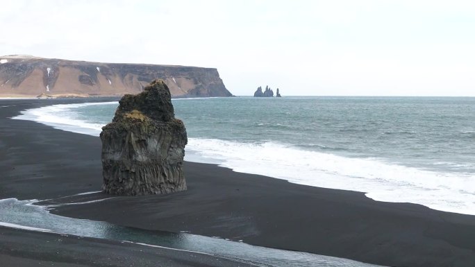 大西洋上的大悬崖。冰岛。大西洋的海浪。狂野的大西洋海岸。黑色火山海岸悬崖。石礁和海水