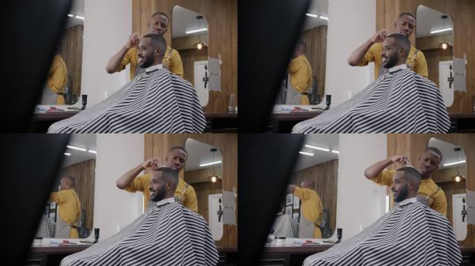 熟练的理发师在沙龙室内与男性客户一起用剪刀剪头发