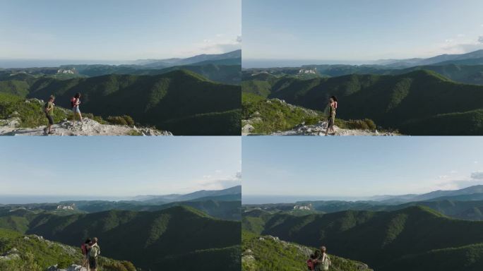 登山夫妇登上山顶欣赏海岸山景