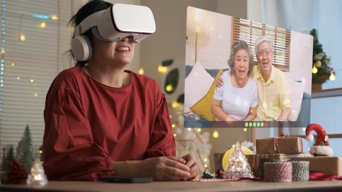 一名亚洲女子用虚拟现实眼镜给家里的父母打圣诞视频电话