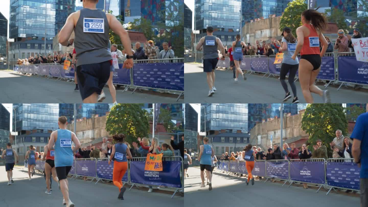 后景:不同群体的马拉松慢跑者争夺第一名，在城市小道上跑步。观众为参加比赛的亲人鼓掌欢呼