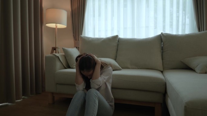 一位饱受压力和抑郁折磨的亚洲女性，她把自己一个人关在卧室里。