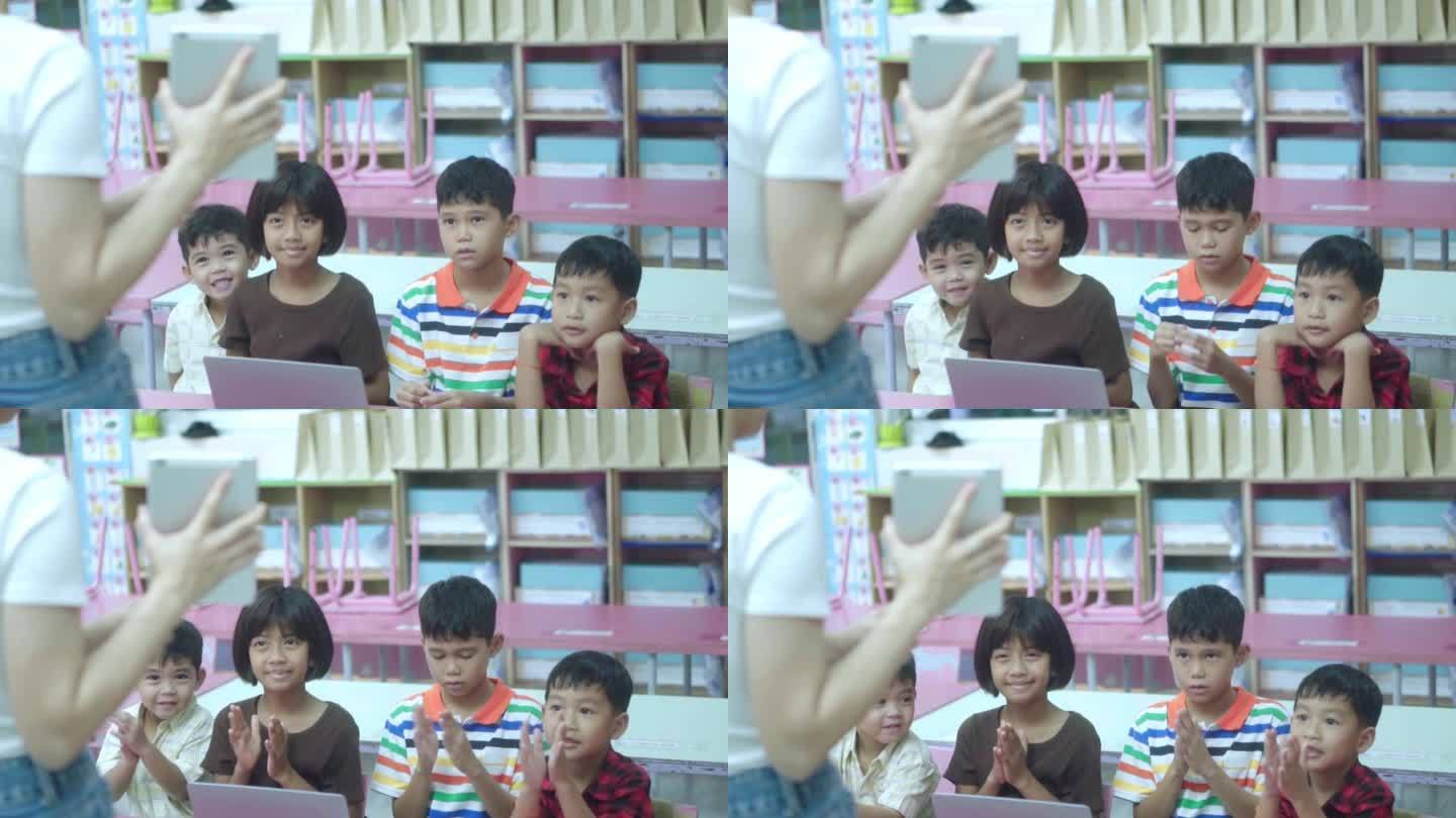 一群学校的亚洲孩子坐在教室里，举起手臂回答老师的问题。回归学校和教育理念。慢镜头
