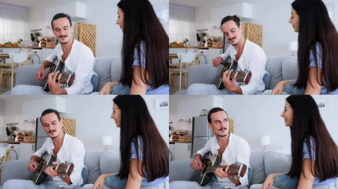 幸福的情侣在家里客厅的沙发上唱着歌弹着吉他