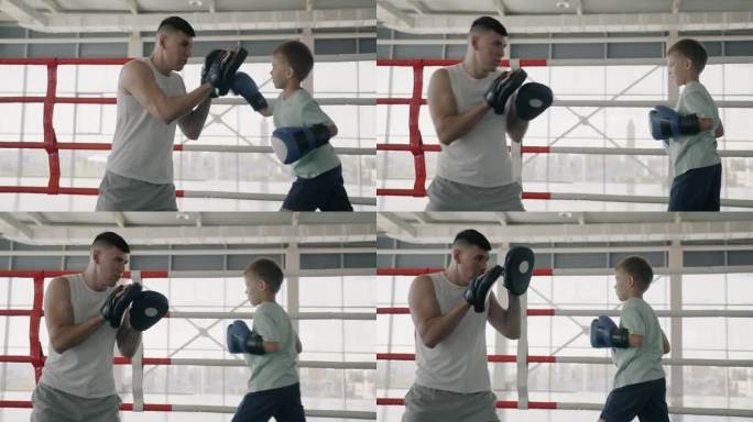 在体育俱乐部里，拳击教练在教小孩子出拳，他在和一个男孩对打