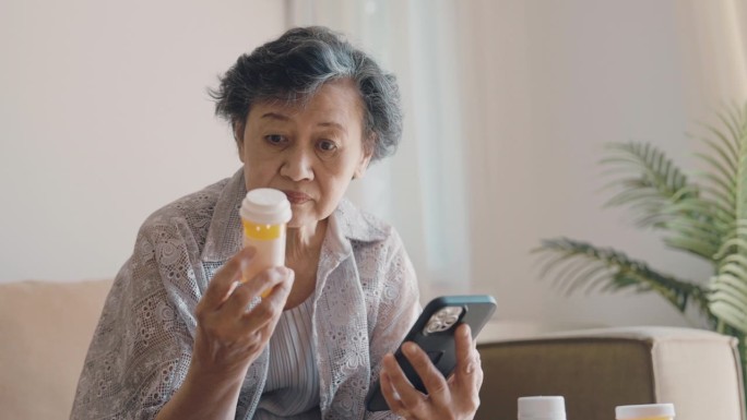 一位老年妇女在家时用智能手机在线购买药品。