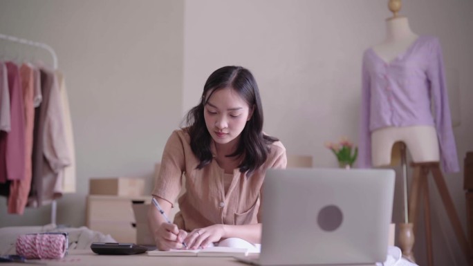 年轻的亚洲女企业家使用计算器计算销售产品的金融价格，中小企业在线业务。