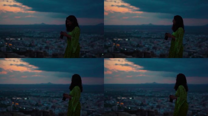 古吉拉特邦古吉拉特邦库奇市，年轻的印度女子手持相机观看布吉市的剪影。女摄影师在深夜拍摄。旅游和假期的