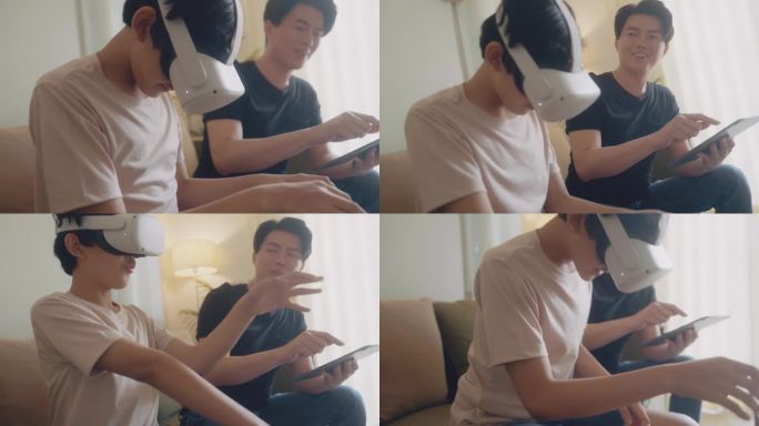 亚洲父亲拿着平板电脑，儿子戴着虚拟现实眼镜，坐在沙发上一起玩游戏。