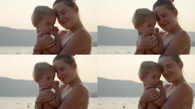 夕阳下的海滩上，母亲抱着儿子的剪影。假期、暑假、旅游。
