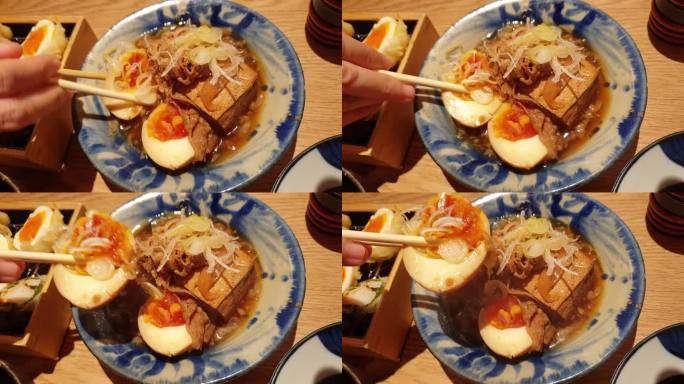 用手筷子吃小配菜的日本居酒屋料理豆腐炖牛肉和鸡蛋菜4k