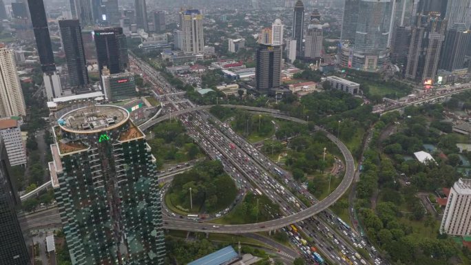 白天飞行在雅加达市中心的交通街道道路交汇处空中俯视全景4k延时拍摄印度尼西亚