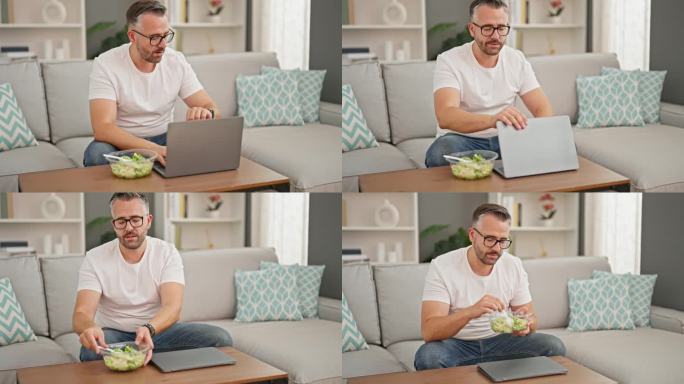 头发花白的男人在家里用笔记本电脑吃沙拉