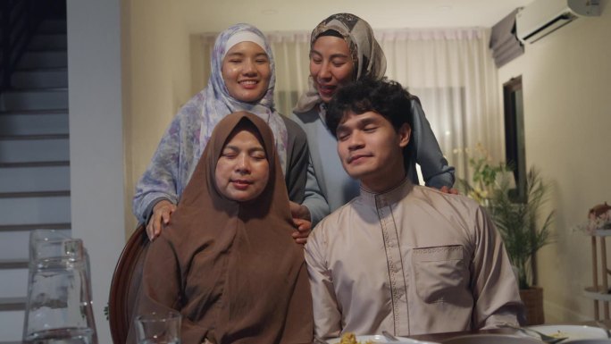 快乐的亚洲穆斯林家庭在线问候庆祝与表弟遥望摄像机视频一起在家叫斋月晚餐。一起庆祝开斋节。