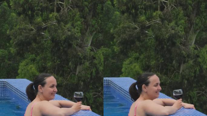 女子在室外游泳池休息时喝葡萄酒