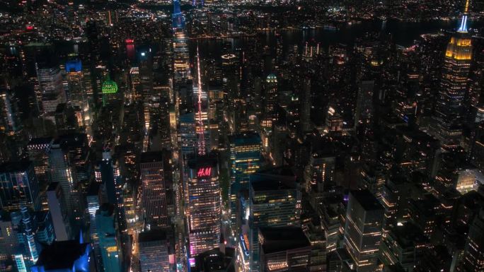 晚上的纽约混凝土丛林。从直升机环游大苹果的航拍画面。娱乐区和时代广场周围的现代摩天大楼