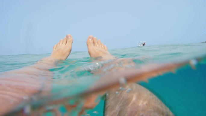 从水下的海浪漂浮的脚光线照射通过从表面清澈的蓝色水自然背景