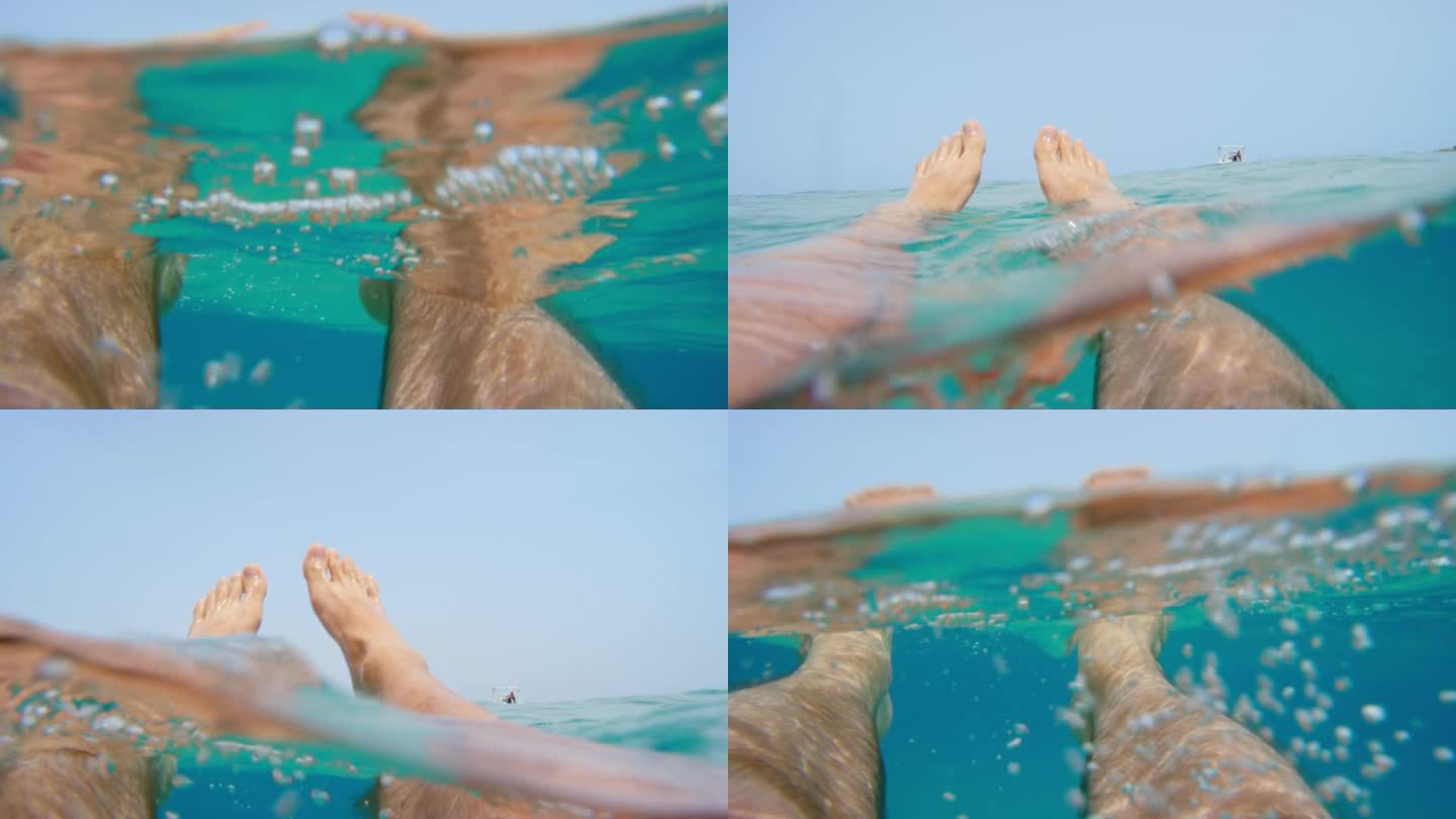 从水下的海浪漂浮的脚光线照射通过从表面清澈的蓝色水自然背景