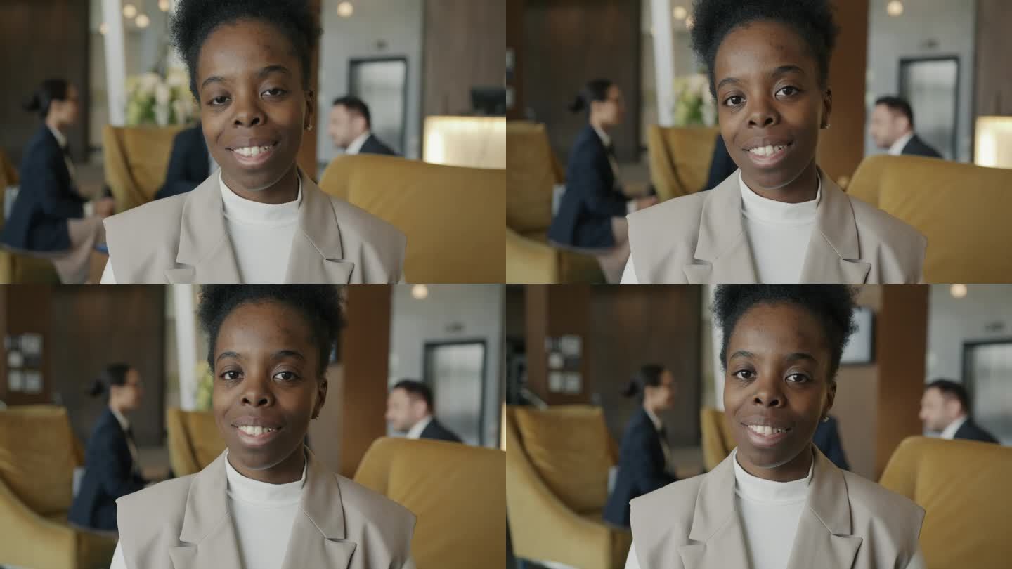 在现代化的酒店大厅里，一个开朗的非裔美国女商人的肖像微笑着