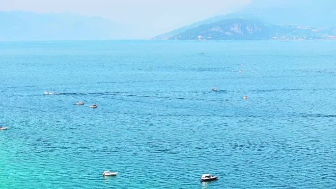 摩托艇在宁静的意大利加尔达湖上颠簸。下沉无人机视图