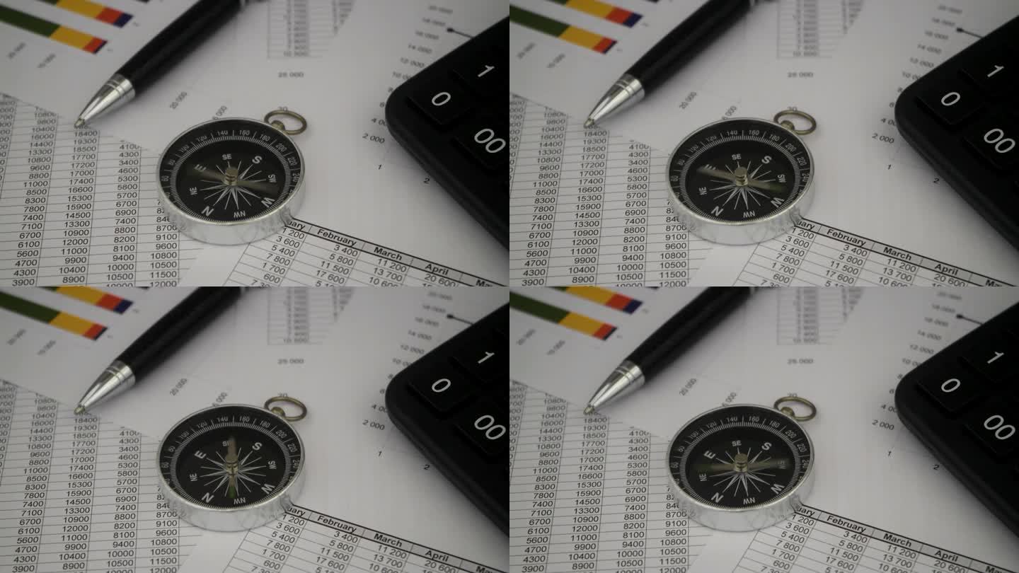 用笔和计算器在财务报告上旋转指南针。