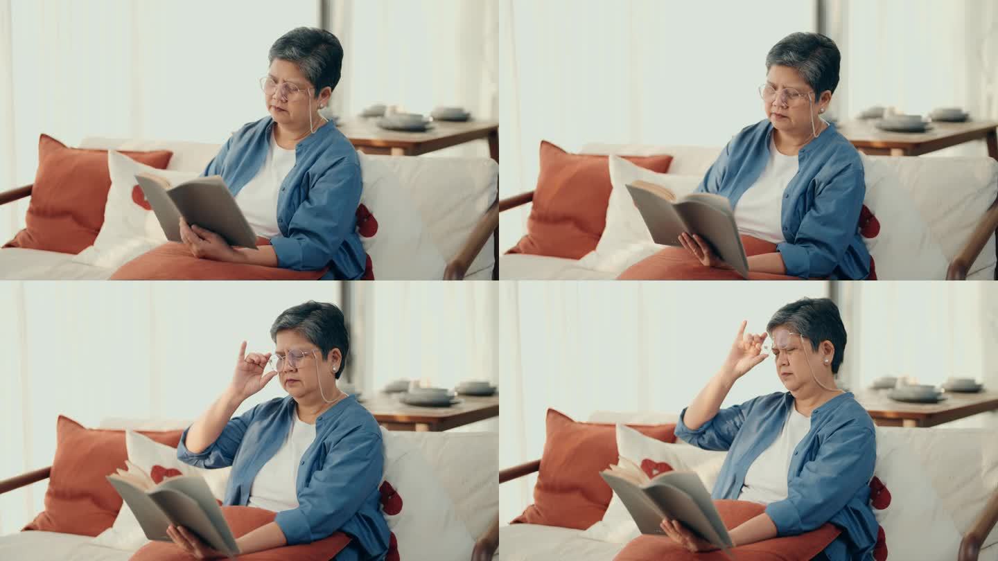 平静与安详:亚洲老妇人沉浸在文学中，在她舒适的客厅里寻找孤独