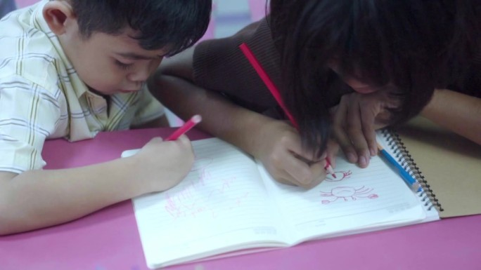 亚洲孩子在学校创意涂色书艺术工作坊。