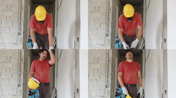 一名建筑工人手持冲击钻的肖像。公寓或房子的建造、修理和翻新