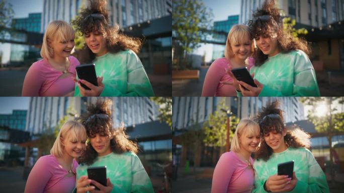 两个年轻时尚的女性朋友在城市街道上聊天，用智能手机浏览社交媒体帖子。两个时髦的女人在市中心外面讨论时