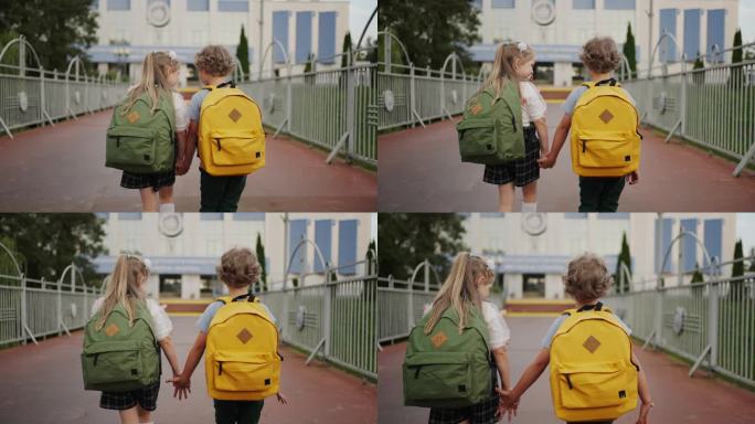 最好的朋友，小男孩和小女孩在秋天牵着手去上学，后视图