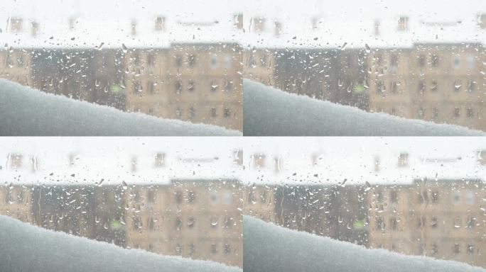 窗外的景色到冬天解冻了。融化的雪堆和雨滴落在玻璃上。多层建筑，有很多窗户。忧郁和泪水还是春天的到来。