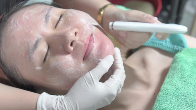 使用超声波洗肤器去除面部污垢和死皮细胞，在美容诊所，医学和美容皮肤科预约概念。