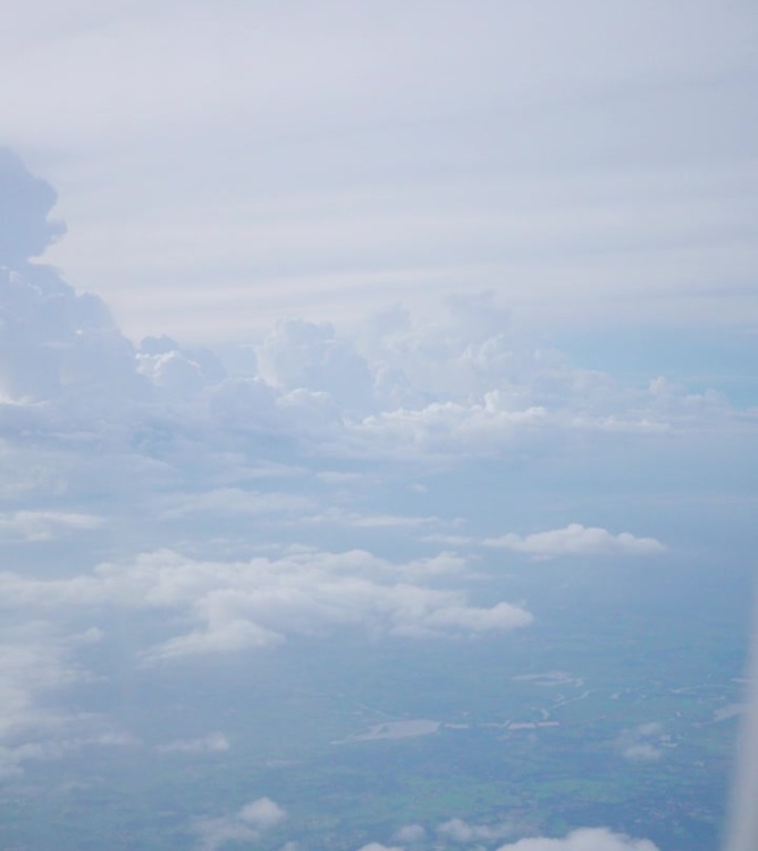 一位旅行的乘客在飞机上透过窗户拍照。