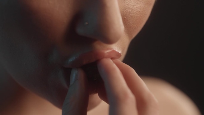 性感的女人用红色的口红工作室拍摄咬一口草莓