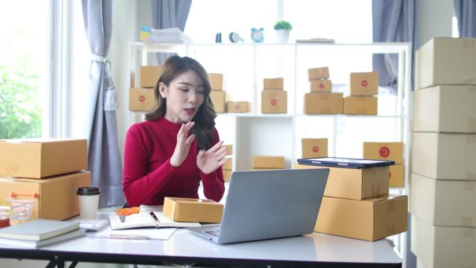 年轻的亚洲女性在家里做小生意，做直播，在网上和客户谈销售。