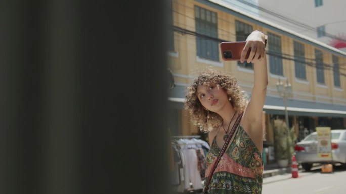 年轻夫妇站在街上，用智能手机在城市里开心地度假自拍，背景是古老的建筑。