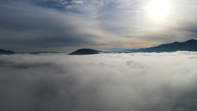 飞过山顶的云层。山峰高耸，清晨日出，自然景观优美