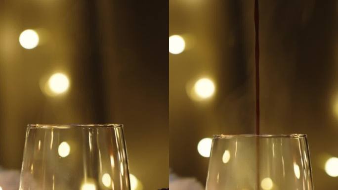 我倒热巧克力，蒸汽在一个花环灯的背景。摆满蜡烛和装饰品的圣诞餐桌。垂直视频。