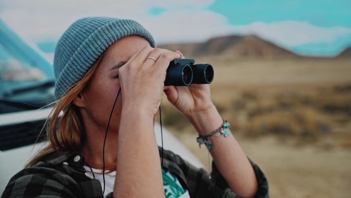 女记者用双筒望远镜探索摩洛哥的沙漠