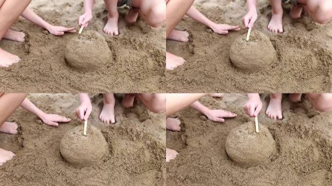 夏天，孩子们在海滩上用手玩耍，堆沙堡