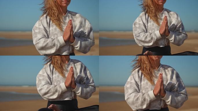在沙滩上以瑜伽祈祷姿势冥想的女人