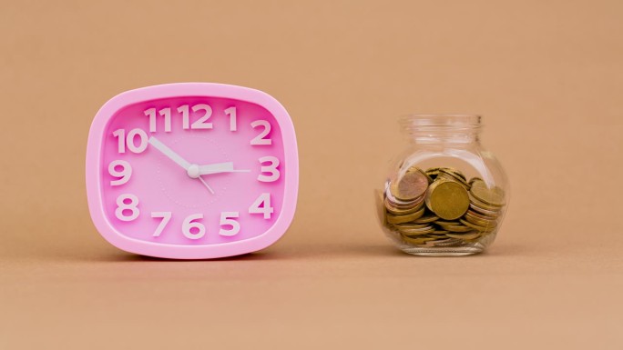 玻璃瓶里的硬币数量在减少。投资。股息。的薪水。现金流。每天的钱。金钱和时间的概念。