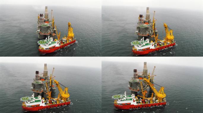 海上石油平台的俯视图，旁边有一艘支持船。
