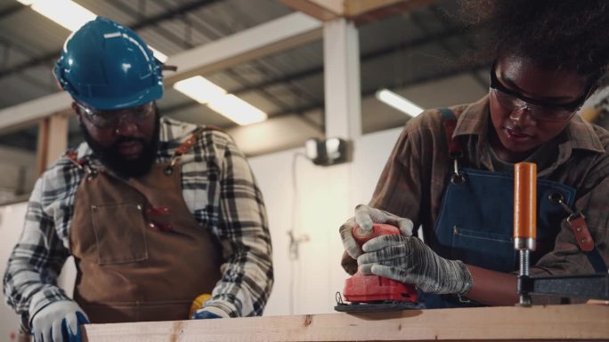 两名非裔美国木匠在家具木材班学习，在车间当木匠。