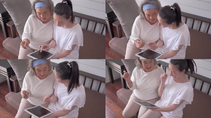 亚洲老年妇女和女儿在家里用平板电脑视频会议