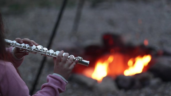 小女孩在火边吹横笛