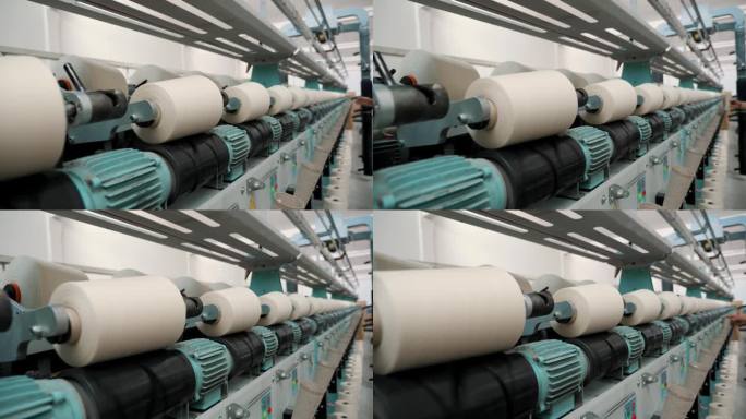 纺织厂设备。纺织工厂。纺纱生产。纱线制作工艺。线生产。近距离的纱线线轴。